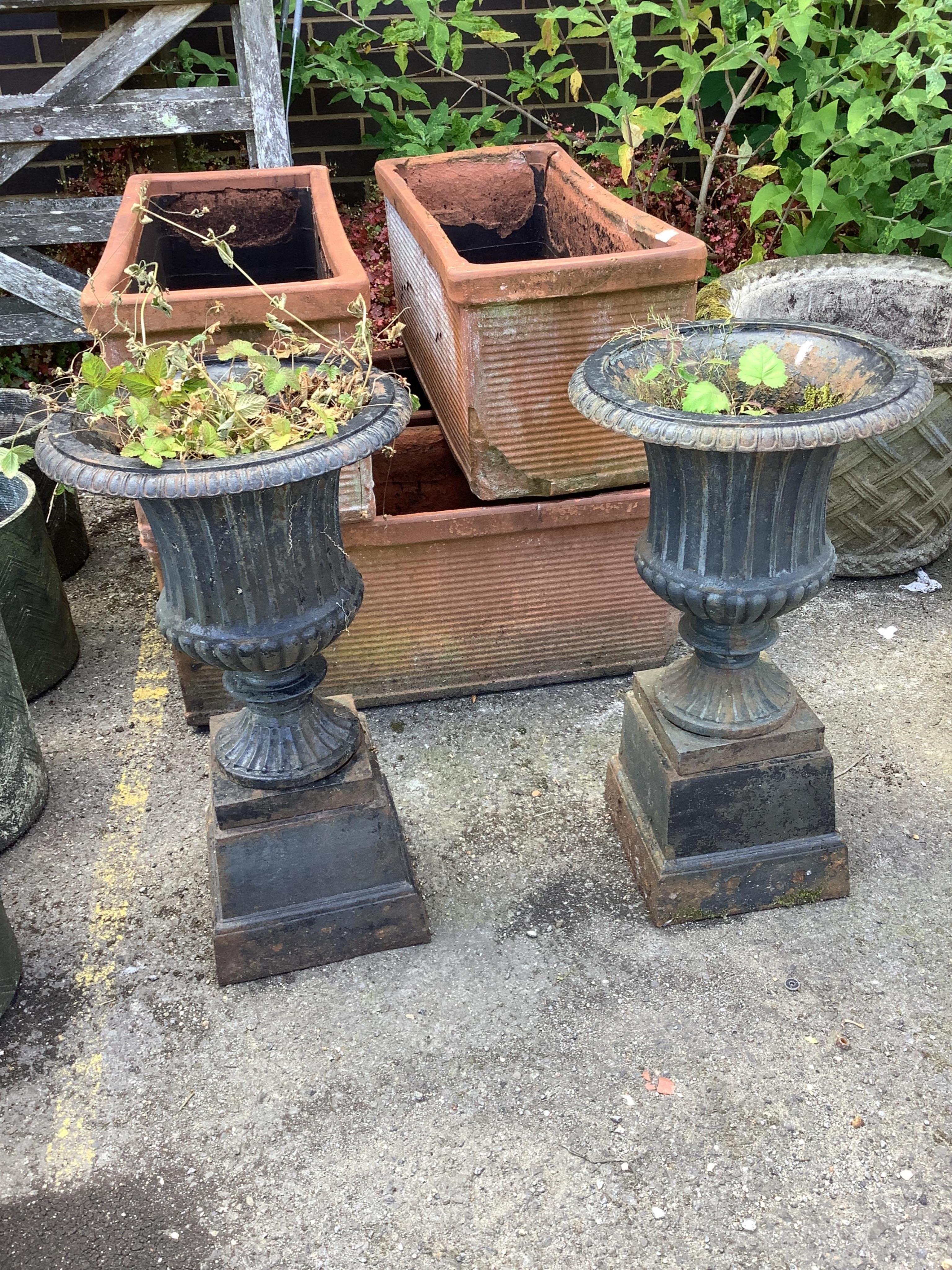 A pair of Victorian style circular black painted cast iron campana urns on stands, diameter 38cm, height 67cm. Condition - fair
